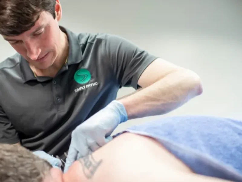 Doctor of Physical Therapy performing dry needling on a patient's shoulder